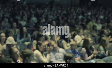 Léger flou artistique des téléspectateurs applaudissant pendant ou après une représentation au théâtre ou dans une salle de concert Banque D'Images