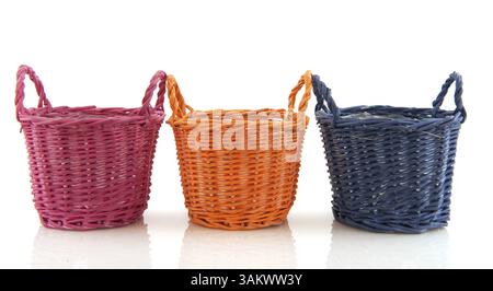 Des paniers vides colorés dans une rangée sur fond blanc Banque D'Images