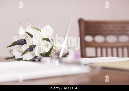 Low angle view of a pretty mariage bouquet de fleurs blanches se trouvant sur une table avec focus sélectif et copyspace Banque D'Images