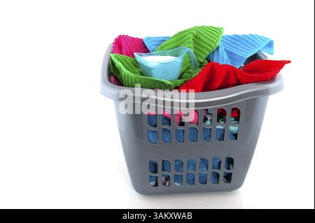 Panier à linge rempli de serviettes colorées isolées sur blanc Banque D'Images