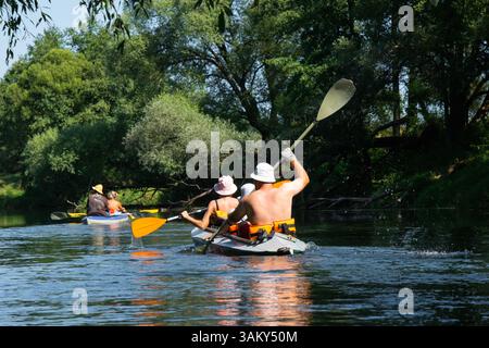 Famille avec enfants en rafting en groupe kayak de différents âges, adultes, personnes âgées. Bateau à rames sur la rivière, randonnée aquatique, aventure estivale. Banque D'Images