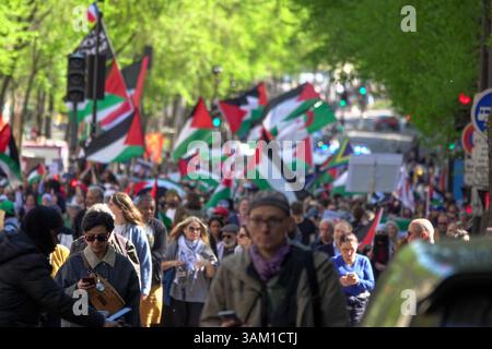 Foule de manifestants défilant à Paris, lors d'une manifestation pro-palestinienne. Les participants brandissent des drapeaux et des banderoles palestiniens en soutien à Gaza Banque D'Images