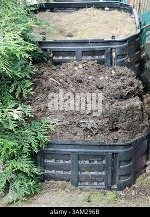 Composteur. Produire votre propre sol fertile dans votre jardin. À l'avant, le compost presque fini, à l'arrière, le début de la production de compost. Banque D'Images