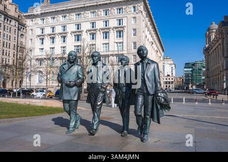La statue des Beatles à Pier Head avec bâtiment néoclassique à Liverpool Banque D'Images
