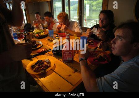 20 juillet 2004 - États-Unis - KRT US NEWS STOPGGED : ENV-RIVERRAT KRT PHOTOGRAPHIE DE KUNI TAKAHASHI/CHICAGO TRIBUNE (août 31) Chad Pregracke, à droite, et son équipage s'assoient autour d'une table pour un repas sur la barge. Pregracke parcourt la rivière à plein temps depuis sept ans. (cdm) 2004 (crédit image : © Kuni Takahashi/mct/ZUMAPRESS.com) Banque D'Images