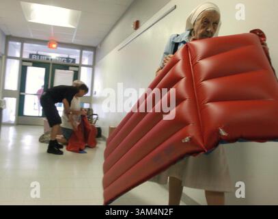 13 août 2004 - États-Unis - KRT US NEWS STORY SLUGGED : WEA-STORMS KRT PHOTOGRAPHIE PAR JULIE FLETCHER/ORLANDO SENTINEL (13 août) TAMPA, FL-- sœur Michaeline Medzihrad porte un matelas pneumatique dans les salles du lycée Sickles à Tampa, Floride vendredi 13 août 2004, en préparation de l'ouragan Charley. (lde) 2004 (crédit image : © Gary Green/mct/ZUMAPRESS.com) Banque D'Images