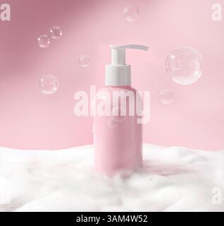 Un flacon à pompe rose élégant et chic entouré de mousse souple et de bulles de savon flottantes Banque D'Images