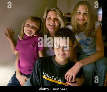 Octobre 27, 2004 - États-Unis - KRT LIFESTYLE STORY SLUGGED : HEALTH-FAM-SŒURS KRT PHOTOGRAPHIE PAR PHIL MASTURZO/AKRON BEACON JOURNAL (10 décembre) quand Alyssa Baynes, 6 ans, à gauche, a été diagnostiquée avec la leucémie il y a trois ans, cela a gardé sa mère Kim Baynes, au centre, occupée et a mené sa sœur, Kristin Willson 13 ans, à droite, et son frère, Ryan Willson, 11 ans, dans le programme ''Supporting Super Kids''. La famille est montrée à leur domicile de Kent, Ohio, en octobre 2004. (nk) 2004 (crédit image : © Phil Masturzo/mct/ZUMAPRESS.com) Banque D'Images