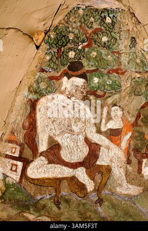 Murale dans la cour du monastère de Hemis représentant un yogin assis et une figure de moine plus petite sous un arbre en fleurs dans un cadre pédagogique. Banque D'Images