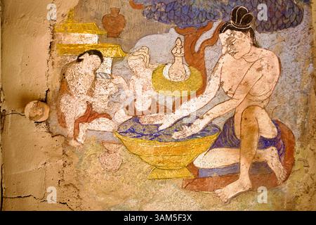 Murale décolorée dans la cour du monastère de Hemis représentant un groupe de personnages se lavant dans un bassin, probablement engagés dans une purification rituelle ou symbolique. Banque D'Images