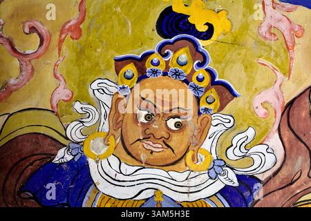 Divinité chauve et courageuse avec une expression exagérée et de grandes boucles d'oreilles dans la murale du monastère Thiksey, Ladakh. Banque D'Images