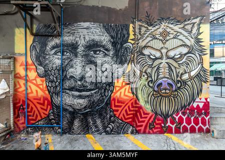 Murale colorée dans un style indigène tribal montrant la tête d’un indigène philippin à côté d’une tête de sanglier à Makati, Philippines Banque D'Images