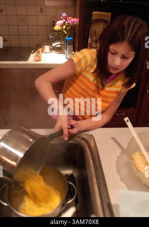 Dec. 13, 2005 - É.-U. - Rebecca Rosen, 10 ans, de Bryn Mawr, Pennsylvanie, aide à préparer des pâtes à base de maïs le lundi 12 décembre 2005. Rebecca a la maladie cœliaque, qui interfère avec l'absorption des nutriments par le corps. Les malades doivent éviter d'ingérer du gluten. (Linda Johnson/Philadelphia Inquirer/KRT) (image crédit : © Linda Johnson/mct/ZUMAPRESS.com) Banque D'Images