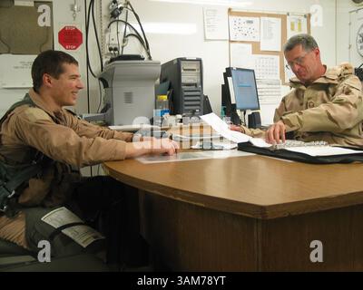 13 février 2006 - États-Unis - après un vol de trois heures dans un F-16 au-dessus du centre de l'Irak le 13 février 2006, le Capitaine Curt Martin, 27 ans (à gauche) partage un moment léger avec le Sgt-maître Richard Snyder, 47 ans, alors qu'ils discutent des performances et de l'état mécanique de l'avion à la base aérienne de Balad en Irak. Les deux hommes sont avec la 122d Fighter Wing basée à Fort Wayne, Indiana. (Dogen Hannah/Contra Costa Times/KRT) (crédit image : © Dogen Hannah/mct/ZUMAPRESS.com) Banque D'Images