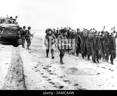Soldats américains marchant un groupe de prisonniers allemands le long de la tête de pont, après quoi ils seront envoyés en Angleterre, Normandie, France, U.S. Army signal corps, 6 juin 1944 Banque D'Images