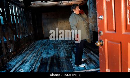 22 mars 2011 - San Bruno, CA, États-Unis - Carlene Vasquez fait un dernier tour d'horizon avant que des travailleurs démolissent la maison familiale à San Bruno, Californie, le 22 mars 2011. La maison a été endommagée de façon irréversible lors de l'explosion d'un gazoduc. La famille envisage de reconstruire. (Gary Reyes/San Jose Mercury News/MCT) (image crédit : © Gary Reyes/MCT/ZUMAPRESS.com) Banque D'Images