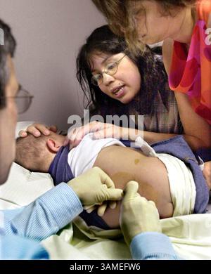 23 avril 2002 - États-Unis - KRT LIFESTYLE STORY SLUGGED : FAM-LEUKEMIA KRT PHOTOGRAPHIE DE FERNANDO SALAZAR/WICHITA EAGLE (14 mai) Suzette Tejada tente de calmer son fils Alex alors qu'il reçoit un robinet spinal du Dr David Rossen à Wichita, Kansas. (WI) NC KD 2002 (Vert) (MV) (diversité) (crédit image : © Wichita Eagle/mct/ZUMAPRESS.com) Banque D'Images