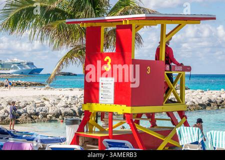 Great Stirrup Cay les Bahamas, rouge jaune tour de sauveteur 3, panneau de drapeau d'avertissement de plage, homme homme sauveteur assis guet, bateau de croisière en fond de mer, co Banque D'Images