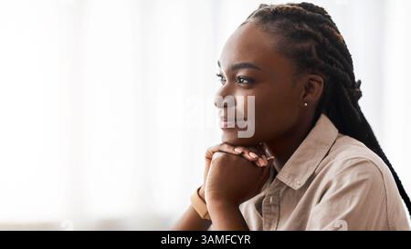 Planifier l'avenir. Vue latérale Portrait de la jeune femme afro-américaine pensive rêvant de jour Banque D'Images