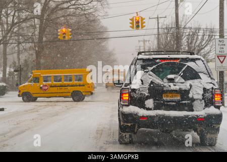 21 janvier 2014 - Merrick, New York, États-Unis - on voit des autobus scolaires se déplacer lentement dans les rues enneigées lorsque les villes de long Island déclarent une urgence de neige et que l'école ferme tôt, avec jusqu'à 10 pouces de neige attendus. (Crédit image : © Ann Parry/ZUMA Wire/ZUMAPRESS.com) Banque D'Images