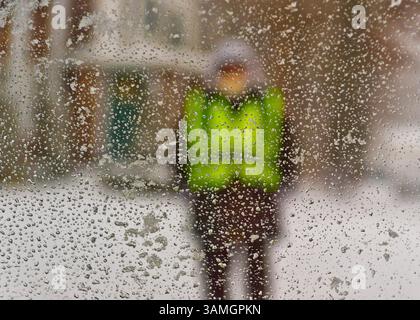 21 janvier 2014 - Merrick, New York, États-Unis - Un gardien de passage scolaire portant un gilet de sécurité vert néon est vu à travers une fenêtre de voiture recouverte de neige, lorsque les écoles ferment tôt alors que les villes de long Island déclarent l'urgence de neige, avec jusqu'à 10 pouces de neige attendus. (Crédit image : © Ann Parry/ZUMA Wire/ZUMAPRESS.com) Banque D'Images