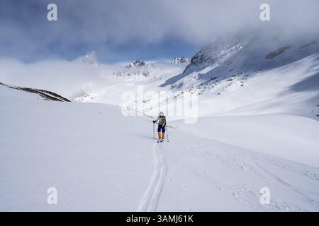 Randonneur de ski montant à travers un paysage de montagne pittoresque enneigé avec vue sur les sommets des montagnes, ascension au sommet de Kesch Pitschen, Buend Banque D'Images