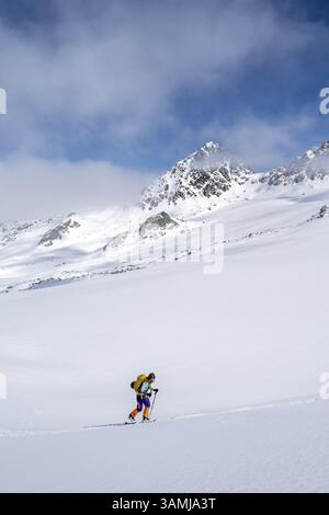 Randonneur de ski montant à travers un paysage de montagne pittoresque enneigé avec vue sur les sommets des montagnes, ascension au sommet de Kesch Pitschen, Buend Banque D'Images