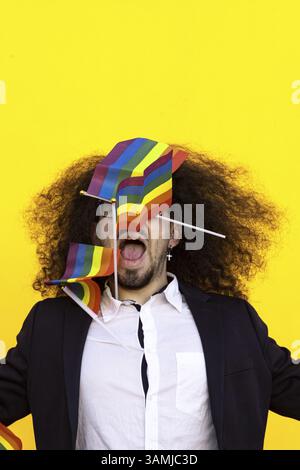 Homme en costume formel tenant le drapeau arc-en-ciel isolé. Homme d'affaires tenant le drapeau arc-en-ciel Banque D'Images