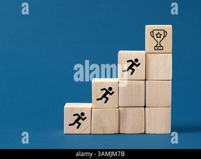 Blocs de bois formant des escaliers avec des figures de bâton de course grimpant vers le trophée représentant la réalisation d'objectifs commerciaux Banque D'Images