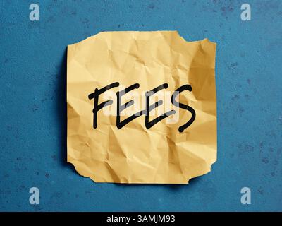 Frais écrits sur un billet de papier jaune froissé sur fond bleu représentant des concepts commerciaux, financiers et fiscaux Banque D'Images