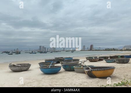 Bateaux à panier, bateaux de pêche et horizon urbain sur la côte pittoresque de la ville de Da Nang au Vietnam Banque D'Images