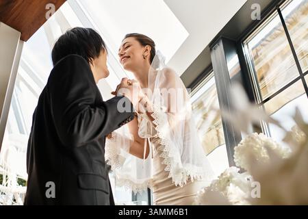 Un couple se connecte joyeusement dans un moment tendre, prêt à se lancer dans leur voyage d'amour ensemble. Banque D'Images