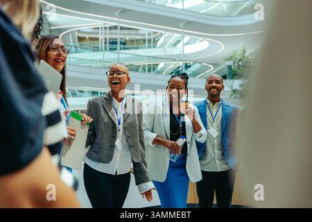 Les employés participent à un événement bancaire en réseau animé, en favorisant les relations et en discutant de la croissance professionnelle dans un environnement de bureau contemporain. Banque D'Images