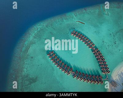 Vue aérienne de l'île de Kuredhivaru avec Resort de luxe et bungalows sur l'eau turquoise, atoll de Noonu, Maldives. Banque D'Images