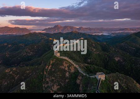 Vue aérienne de la majestueuse Grande Muraille de Jinshanling entourée de montagnes au coucher du soleil, Chengde, Chine. Banque D'Images