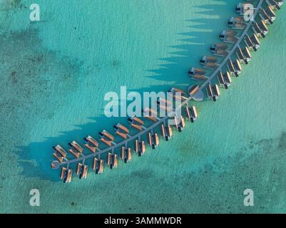 Vue aérienne de l'île de Kuredhivaru avec bungalows de luxe sur l'eau turquoise, atoll de Noonu, Maldives. Banque D'Images