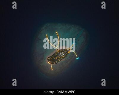 Vue aérienne de l'île illuminée de Kuredhivaru dans un paysage nocturne tranquille, atoll de Noonu, Maldives. Banque D'Images
