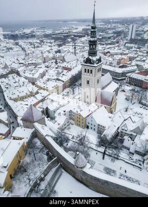 Vue aérienne de la vieille ville enneigée avec église St Olaf et charmants toits, Tallinn, Harju, Estonie. Banque D'Images