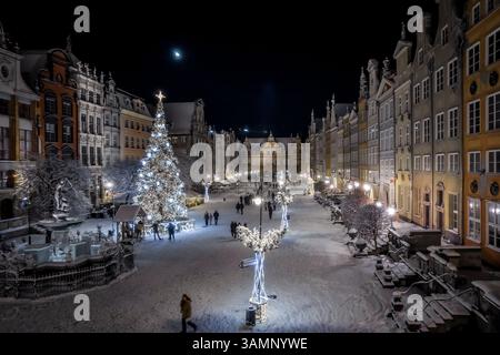 Vue aérienne de la vieille ville décorée pour Noël avec un grand arbre de Noël et statue de Neptun sous le clair de lune, Gdansk, Pologne. Banque D'Images