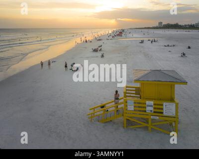 Vue aérienne du coucher de soleil sur le golfe du Mexique avec une maison colorée de sauveteur et des gens sur la plage, Siesta Key, États-Unis. Banque D'Images