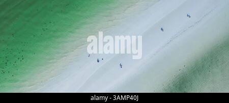 Vue aérienne de la plage turquoise avec des gens marchant sur le rivage de sable, Holbox, Mexique. Banque D'Images
