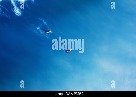 Vue aérienne de surfeurs chevauchant des vagues au Cap, Afrique du Sud. Banque D'Images