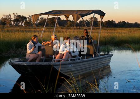 3 mai 2013 - Moremi, Botswana, Afrique - touristes appréciant les derniers rayons de soleil sur l'eau. Moremi Game Reserve est un parc national du Botswana. Il repose sur le côté est du delta de l'Okavango et a été nommé d'après le chef Moremi de la tribu BaTawana. Moremi a été désignée comme réserve de chasse, et non comme parc national permettant aux BaSarwa ou aux Bushmen de demeurer dans la réserve. (Crédit image : © Sergi Reboredo/ZUMA Wire/ZUMAPRESS.com) Banque D'Images
