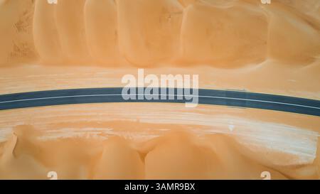 Vue aérienne d'une route courbe vide dans le désert d'Abu Dhabi, U.A.E. Banque D'Images