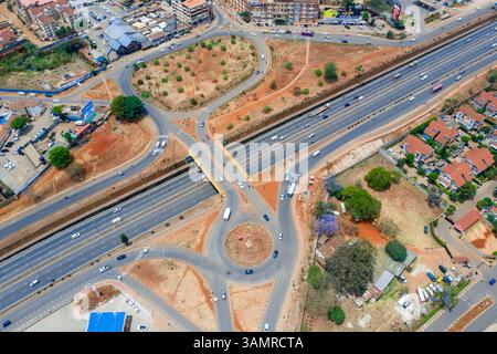 Vue aérienne d'un carrefour urbain animé avec des véhicules sur Thika Road entouré de bâtiments modernes, Kasarani, Nairobi, Kenya. Banque D'Images