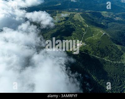 Vue aérienne des montagnes sereines et majestueuses entourées de forêts luxuriantes et de vallées étendues sous un ciel tranquille, Lautenbachzell, France. Banque D'Images