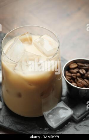Liqueur de crème de café en verre, glaçons et haricots sur la table, gros plan Banque D'Images