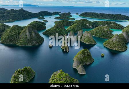 Vue aérienne des îles dispersées avec l'eau bleue de l'océan à Wajag Island, Raja Ampat, Papouasie occidentale, Indonésie. Banque D'Images