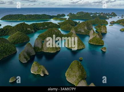 Vue aérienne des îles dispersées avec l'eau bleue de l'océan à Wajag Island, Raja Ampat, Papouasie occidentale, Indonésie. Banque D'Images