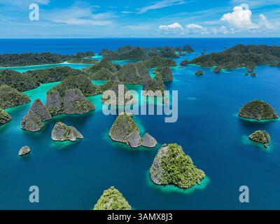 Vue aérienne des îles dispersées avec l'eau bleue de l'océan à Wajag Island, Raja Ampat, Papouasie occidentale, Indonésie. Banque D'Images